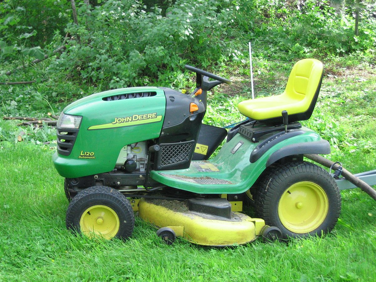 Tracteur tondeuse autoportée John Deere sur une pelouse verte arborée